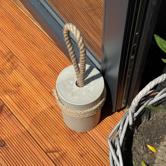 Handmade concrete door stop detail showing jute rope handle and string wrapping