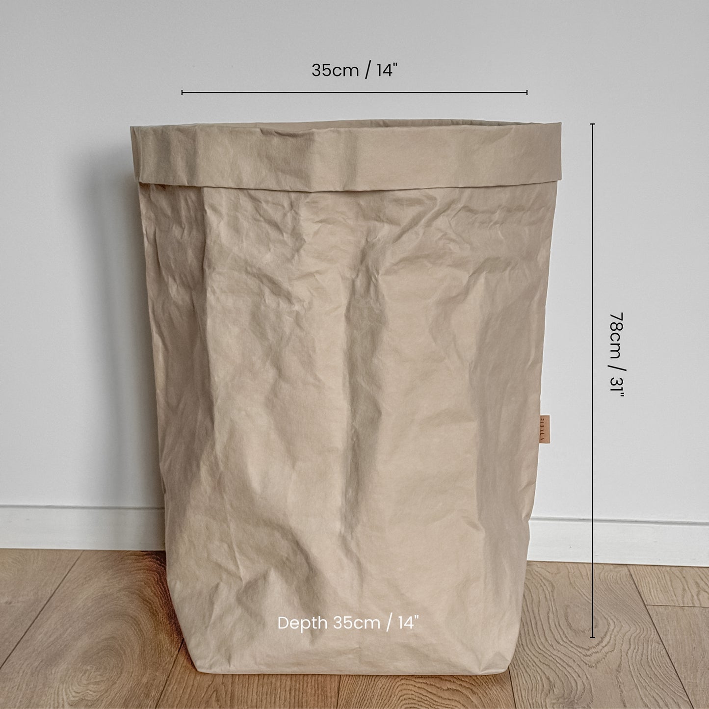 Grande size washable paper bag with dimensions marked on a wooden floor.