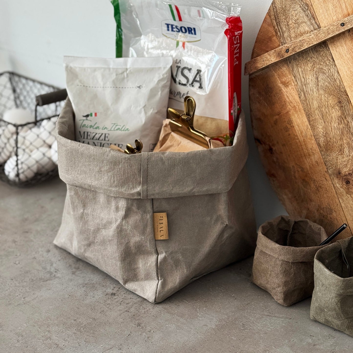 Large chino brown washable paper bag filled with groceries on concrete counter.