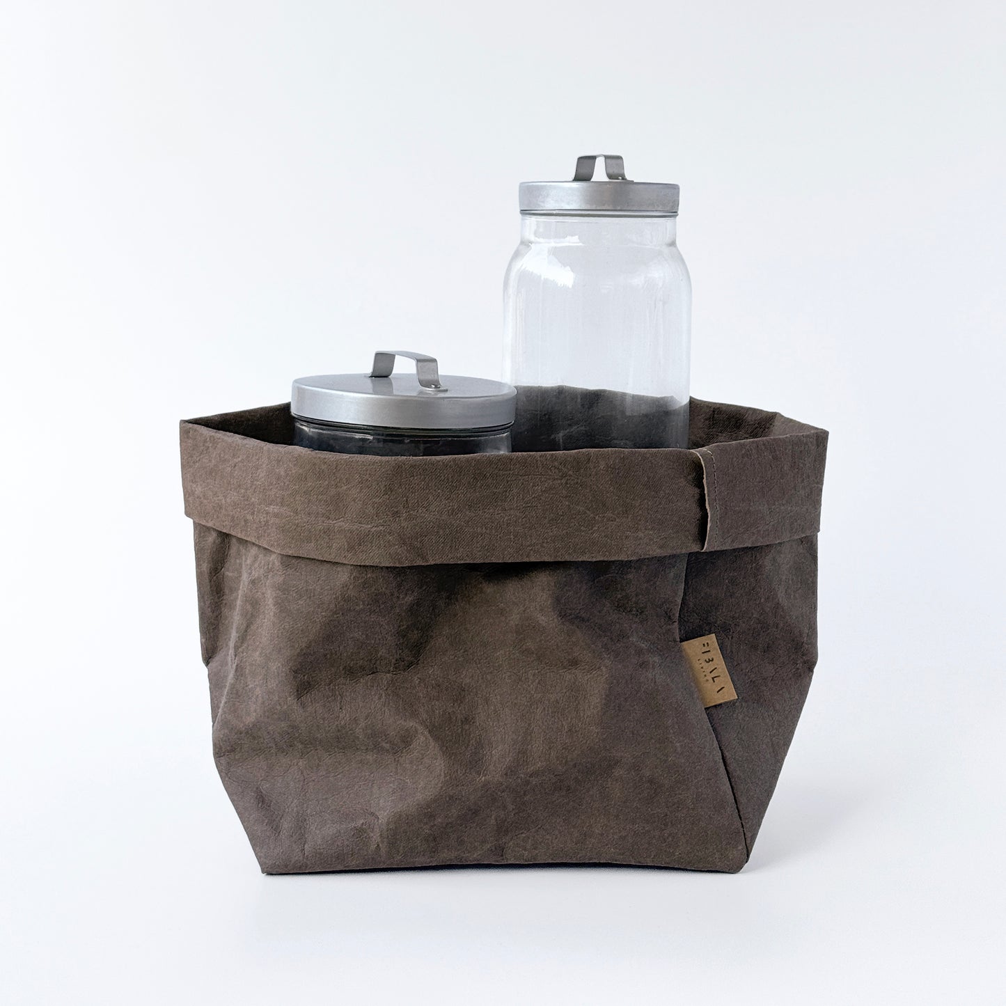Large cocoa brown washable paper bag with two jars on white background.