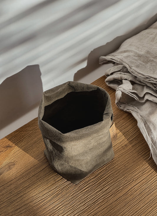 Washable paper storage bag on a wooden surface with a neutral background