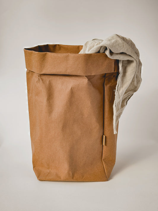 XXL washable paper storage bag with a linen throw draped over the rolled top