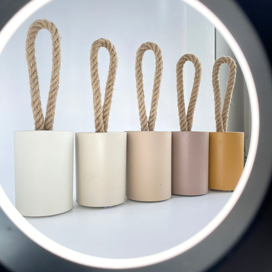 Concrete door stops with jute rope handle in earthy tones lined up