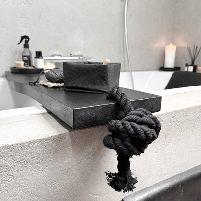 Angle close-up of black live-edge bath caddy, black cotton rope, spa tray detail
