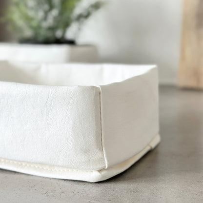 Close-up white washable paper tray texture, blurred backdrop, eco-chic organizer detail