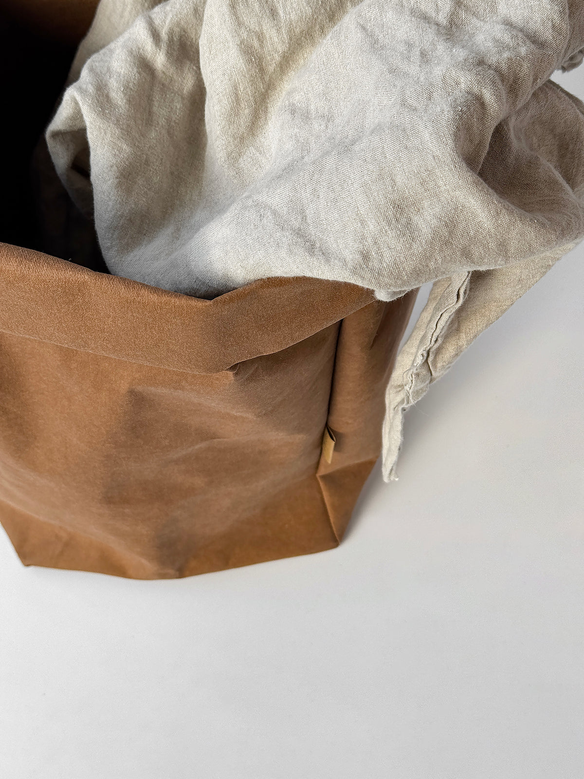 Top view of a cinnamon washable paper bag with a linen blanket inside