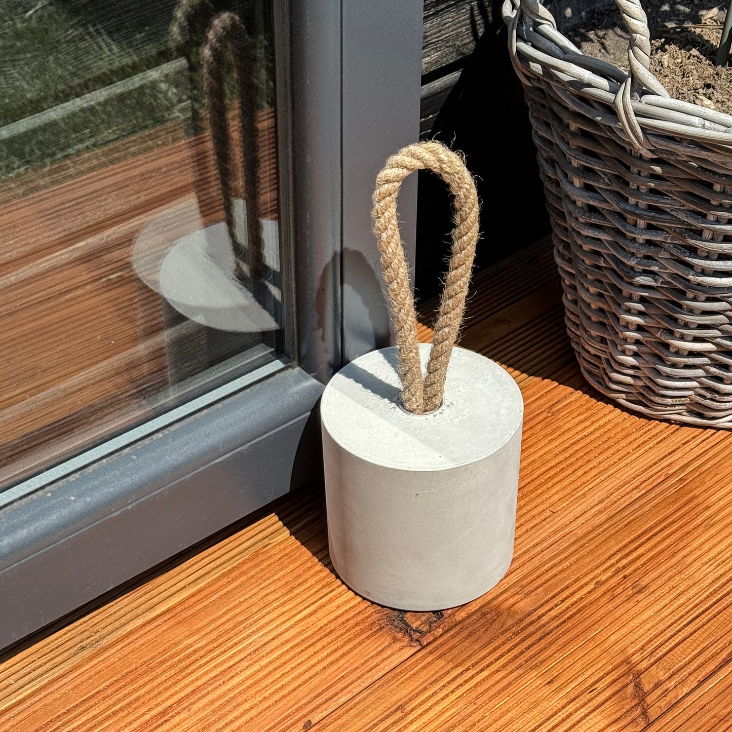 Minimalist concrete door stop with rope handle holding patio door