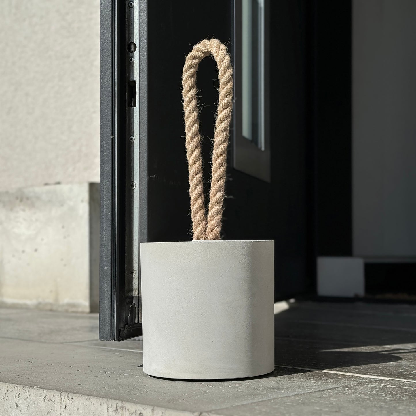 Concrete door stop XL loop design with jute rope handle holding entry door
