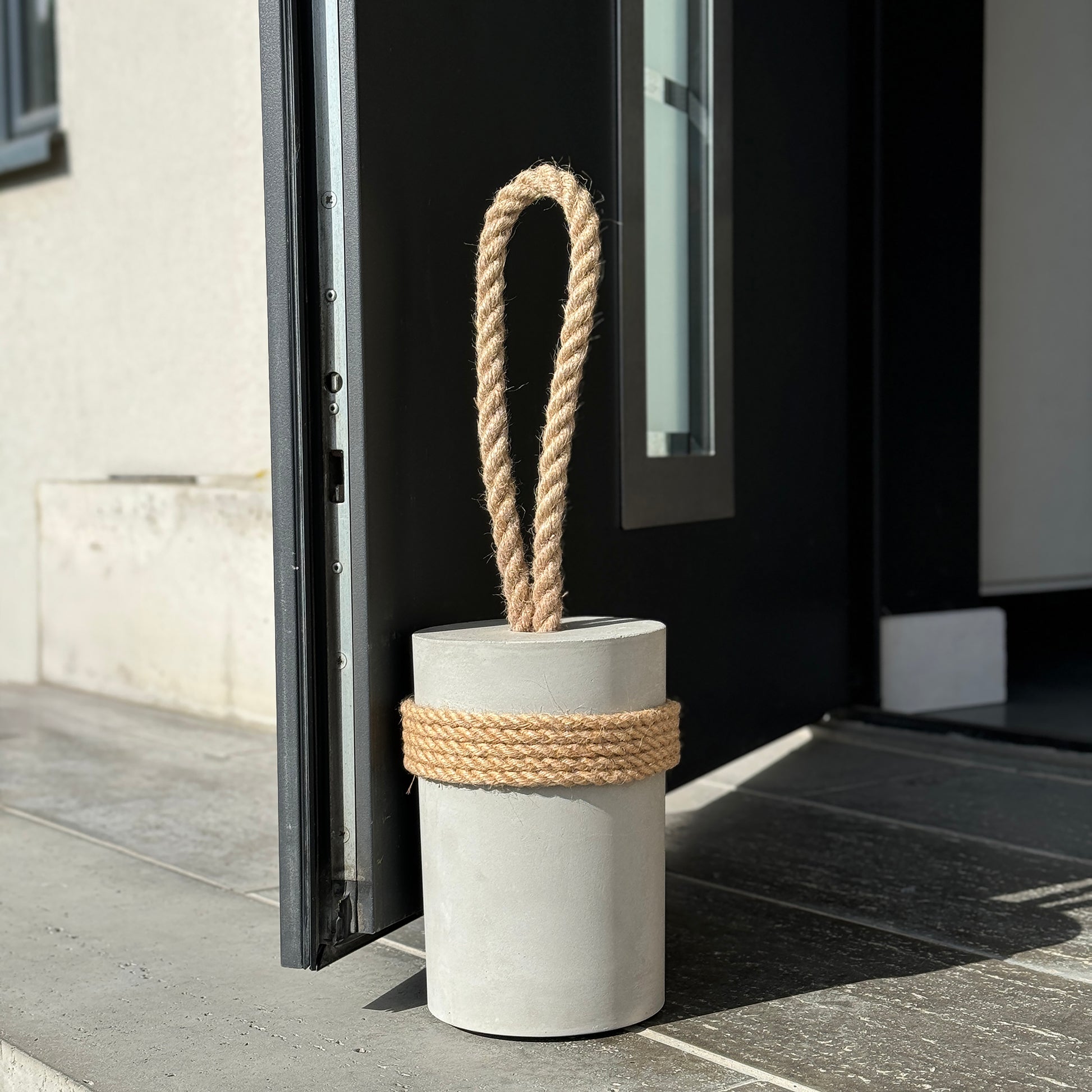 Concrete door stop with jute rope used at  outdoor entrance