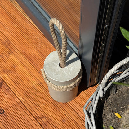 Handmade concrete door stop detail showing jute rope handle and string wrapping