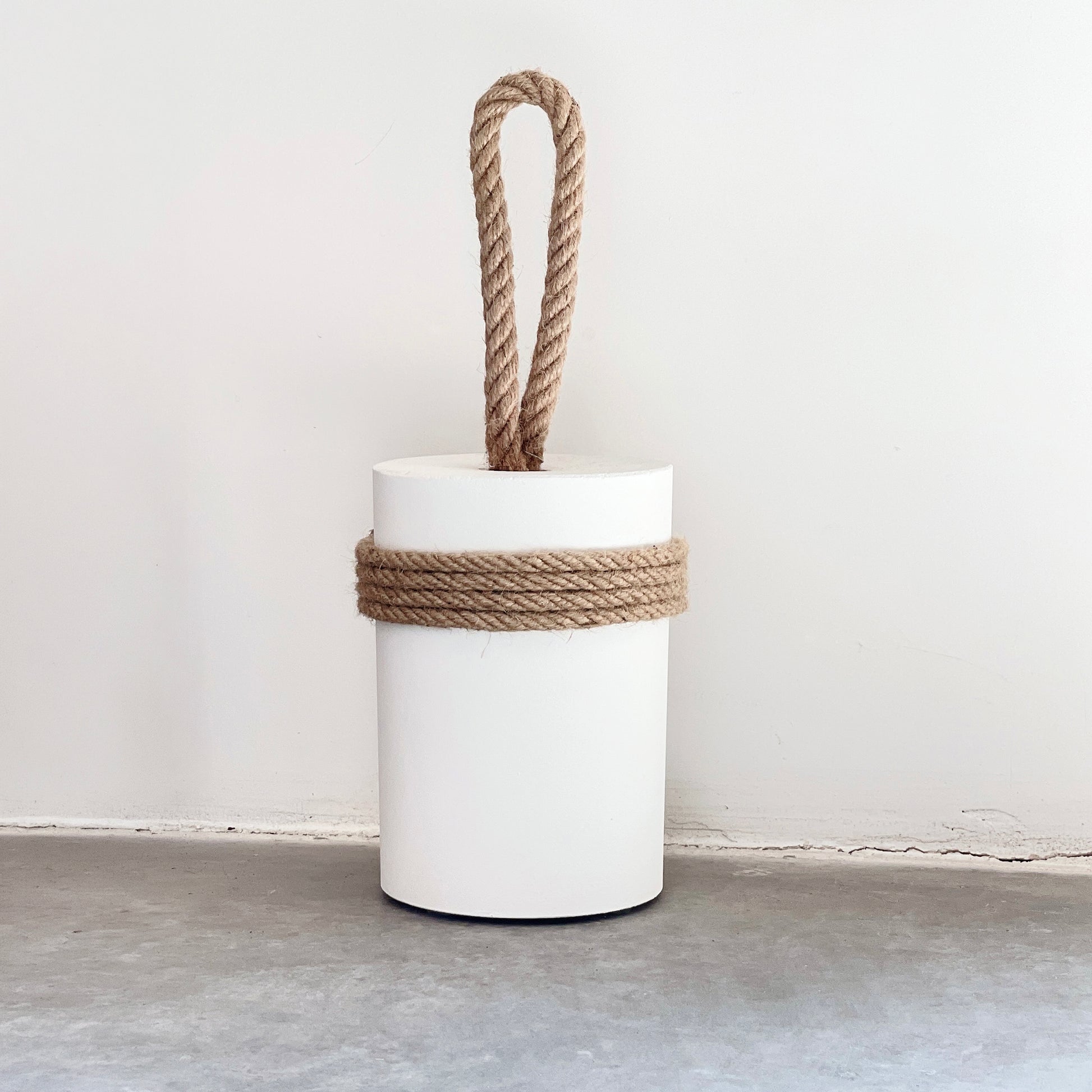 Extra large concrete door stop with jute rope handle and protective jute wrapping on white wall background