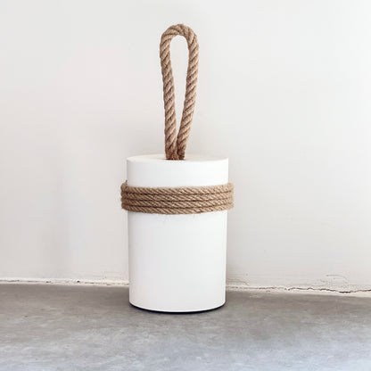 Extra large concrete door stop with jute rope handle and protective jute wrapping on white wall background