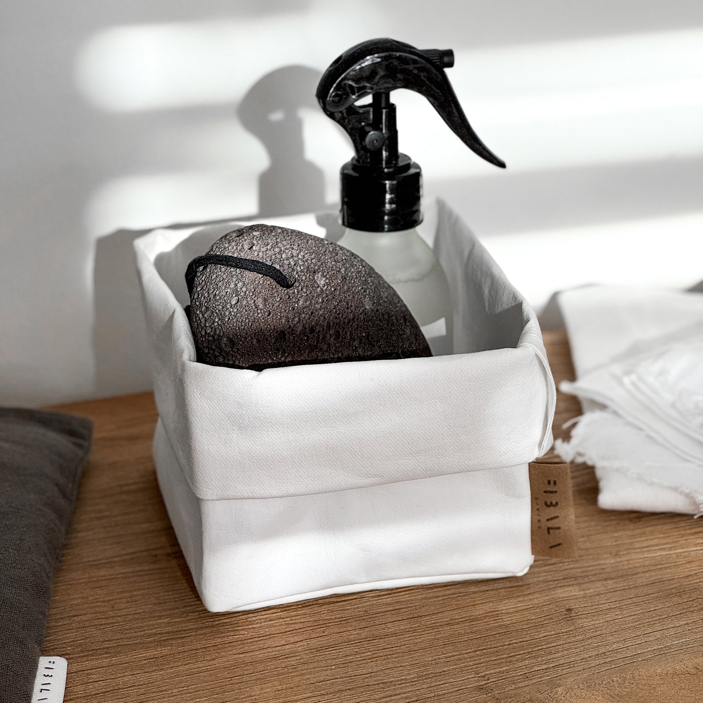 Top-view small white washable paper box, black pumice spray, wood—eco bath set