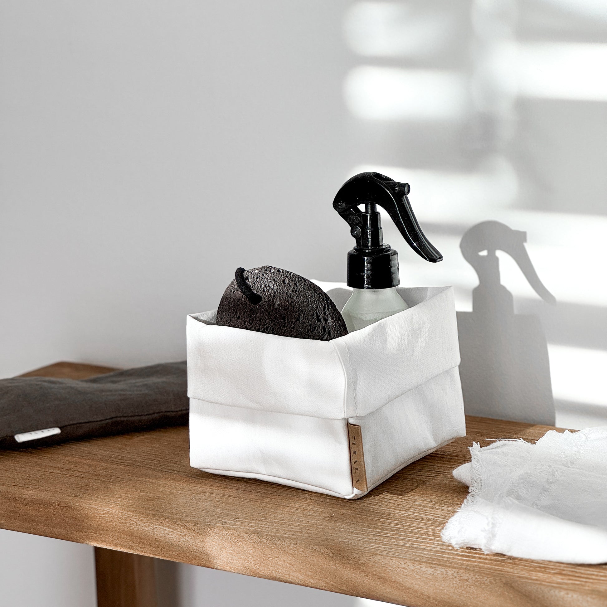 Side-view small white washable paper box, black pumice spray, wood—eco bath set