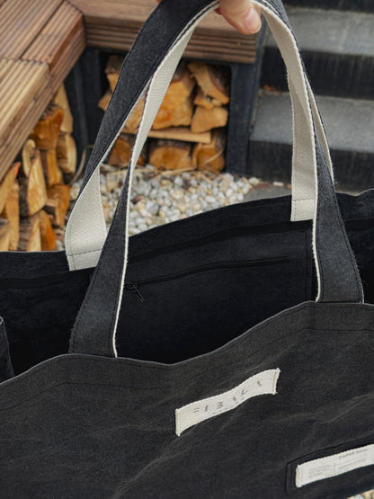 Close-up top view of black washable paper carry-all bag showing zipper pocket detail — Fibala Living XL