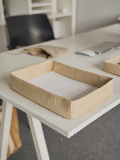Washable paper document tray on a desk with notebooks and papers