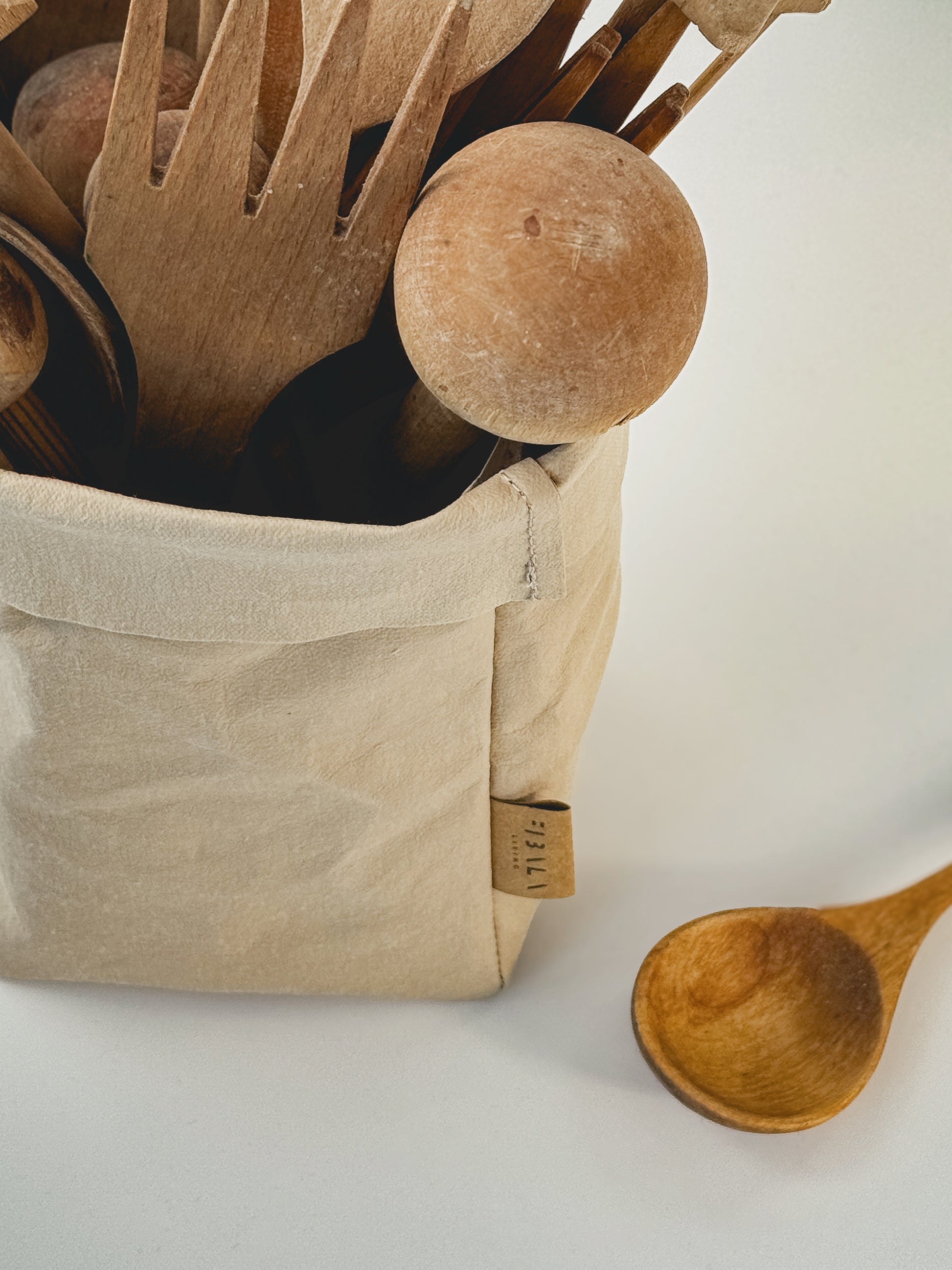 Small beige washable paper bag used as cover for kitchen utensil holder