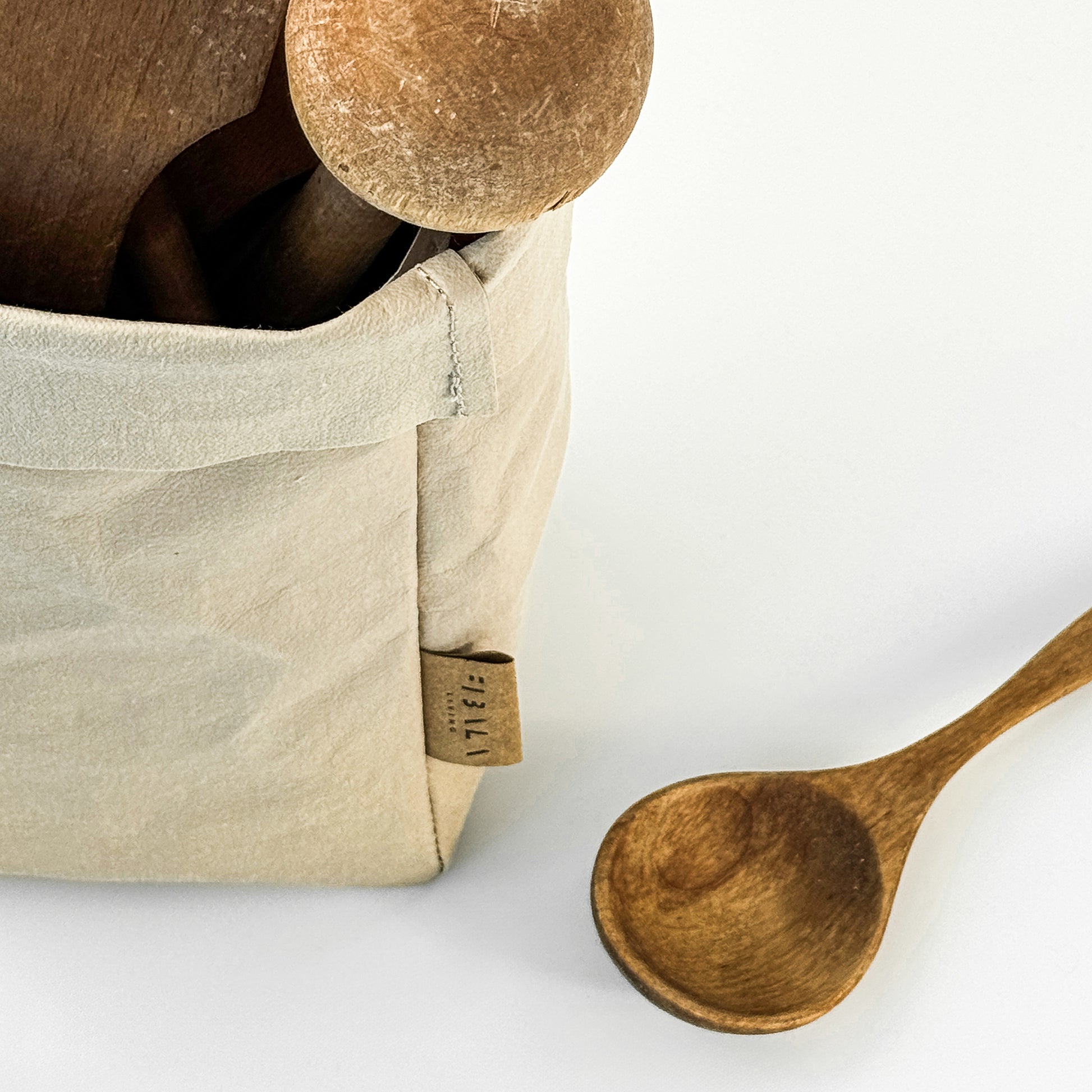 Close-Up of Wooden Utensils in Beige Washable Paper Bag on White Background, Eco-Friendly and Stylish for On-the-Go