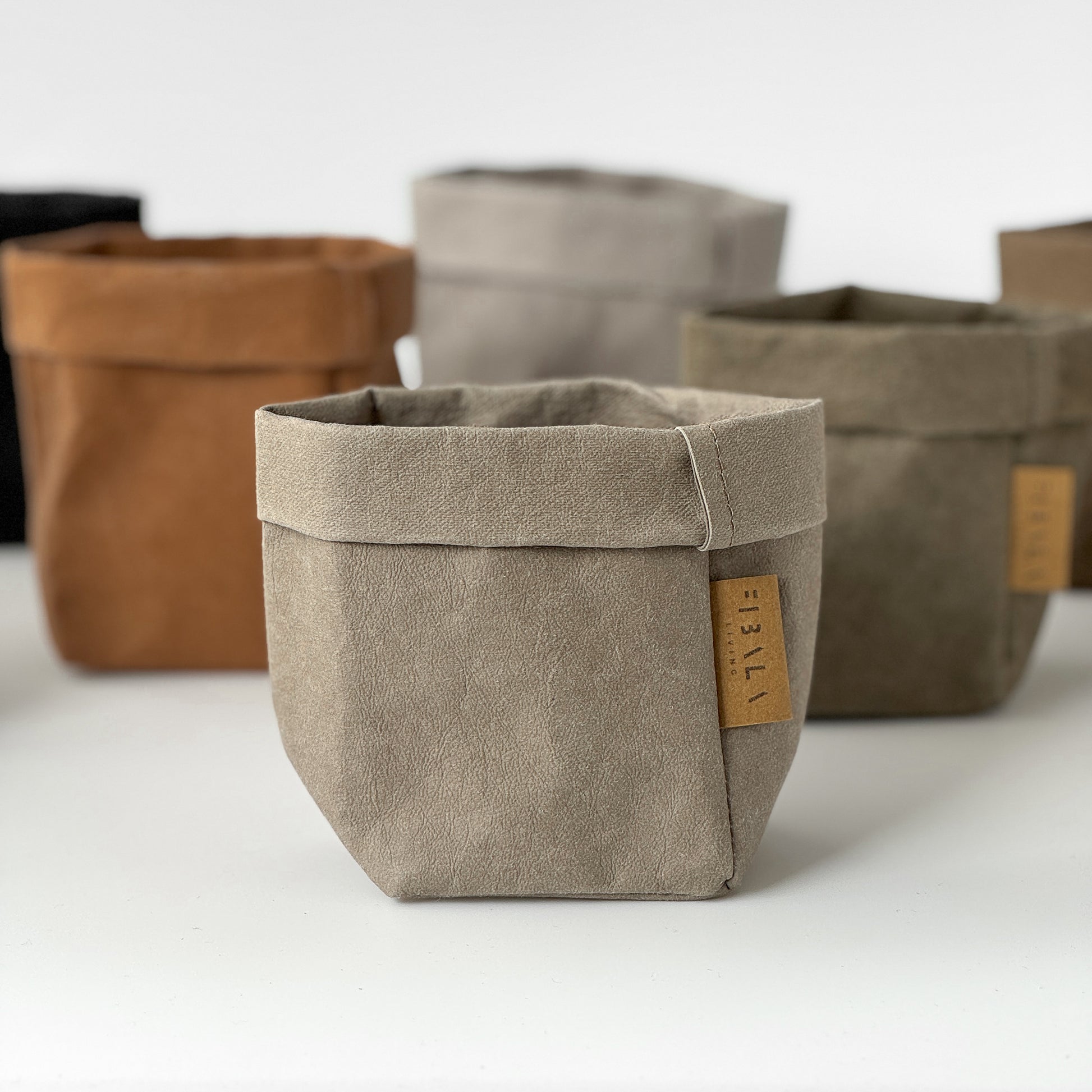 Set of washable paper bags in various colors on a white background