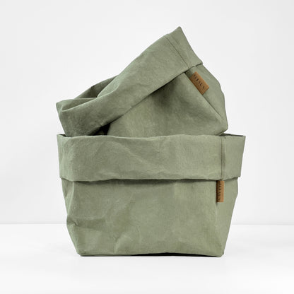 Sage washable paper bags stacked toghether with a brand label on a white background