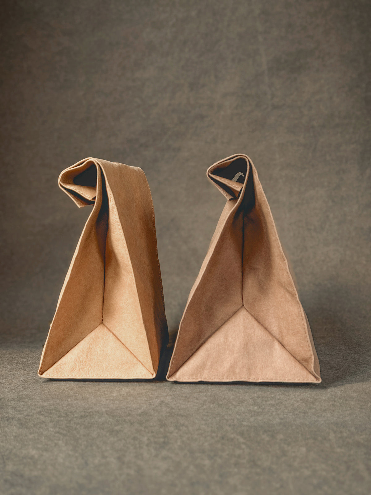 Two caramel washable paper lunch bags from the side, showing the folded base