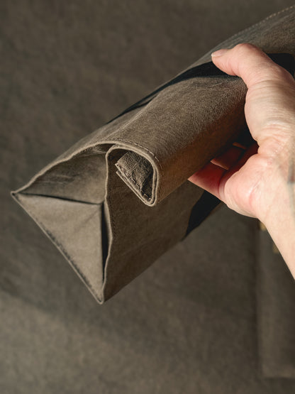 Hand rolling down the top of a washable paper lunch bag