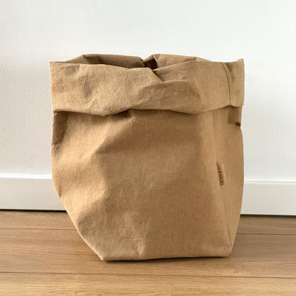 Extra-large brown washable paper bag on wooden floor, white wall background | Reusable eco-friendly bag