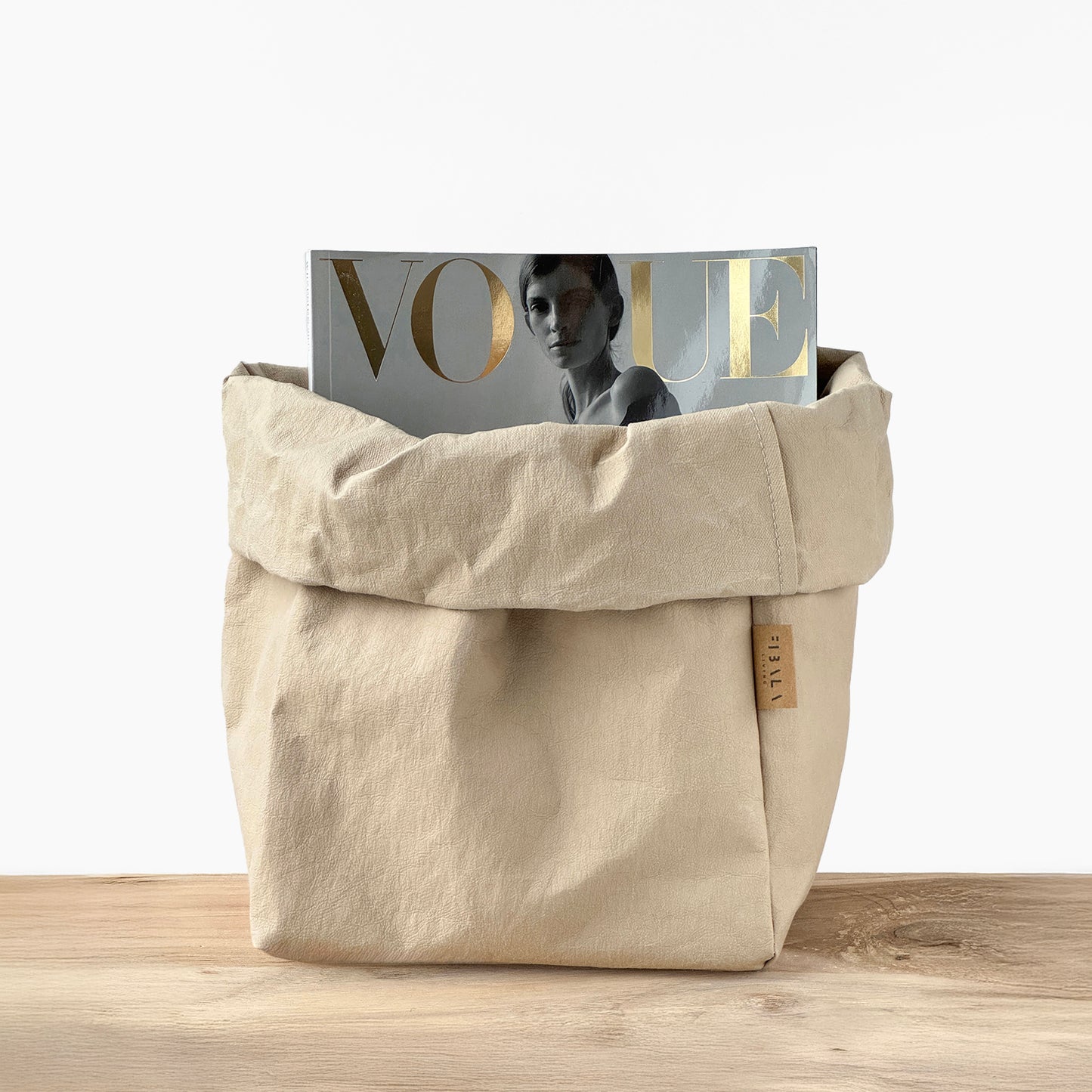 Sand beige washable paper bag with a 'Vogue' magazine on a wooden surface | Reusable eco-friendly bag