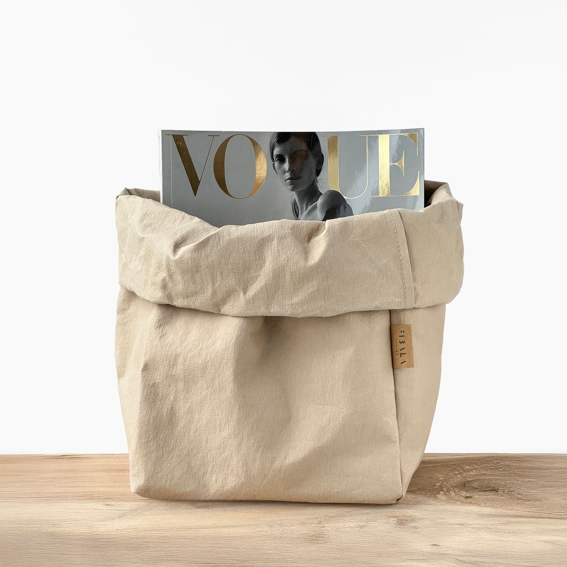 Sand beige washable paper bag with a 'Vogue' magazine on a wooden surface | Reusable eco-friendly bag