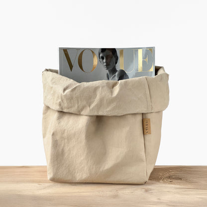 Sand beige washable paper bag with a 'Vogue' magazine on a wooden surface | Reusable eco-friendly bag