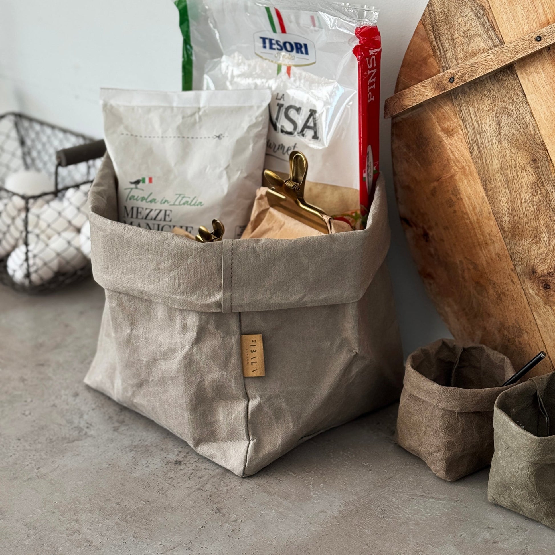 Large chino brown washable paper bag filled with groceries on concrete counter.