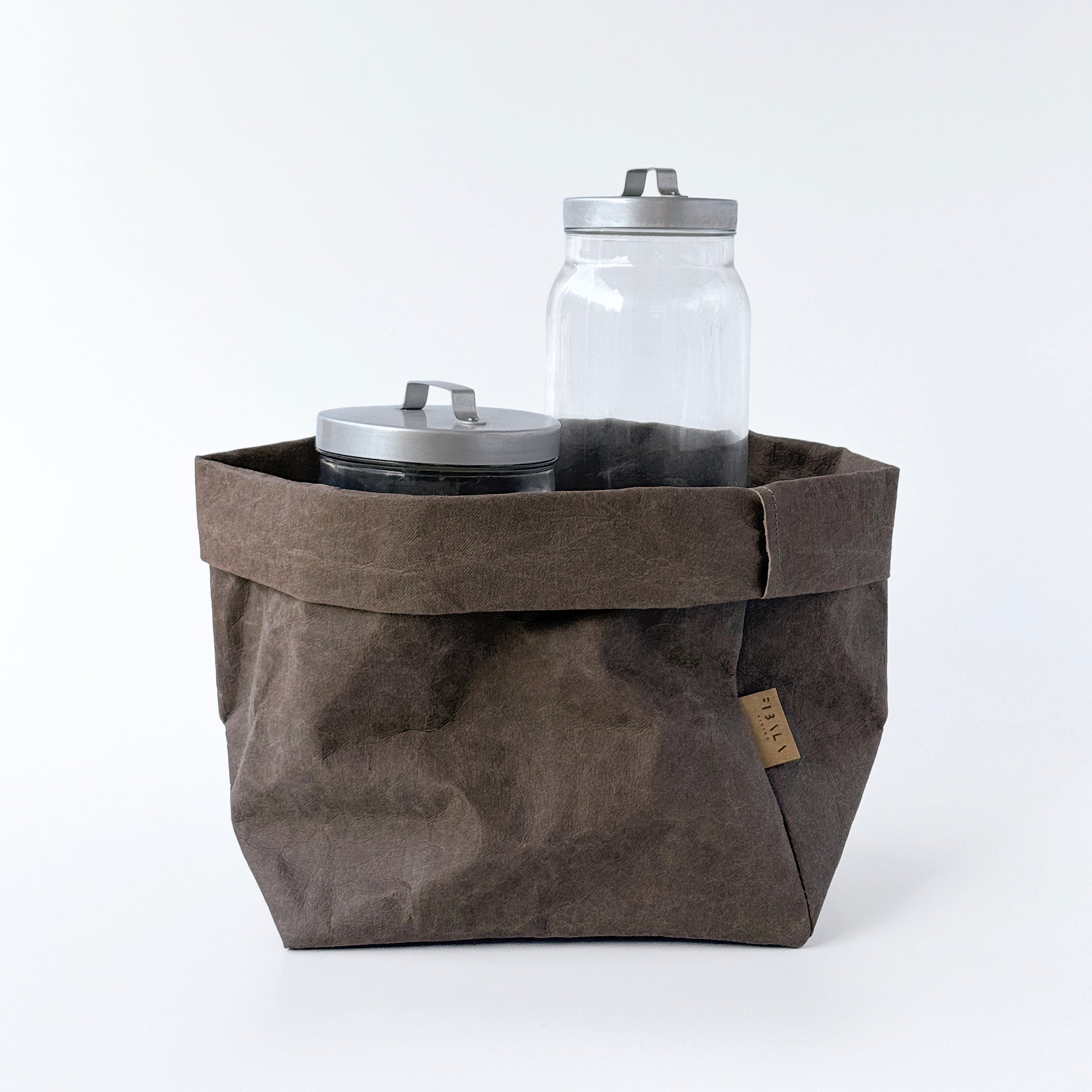 Large cocoa brown washable paper bag with two jars on white background.