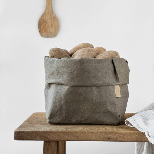 Medium olive-green washable paper bag, potatoes, wood table, white BG—eco reusable tote