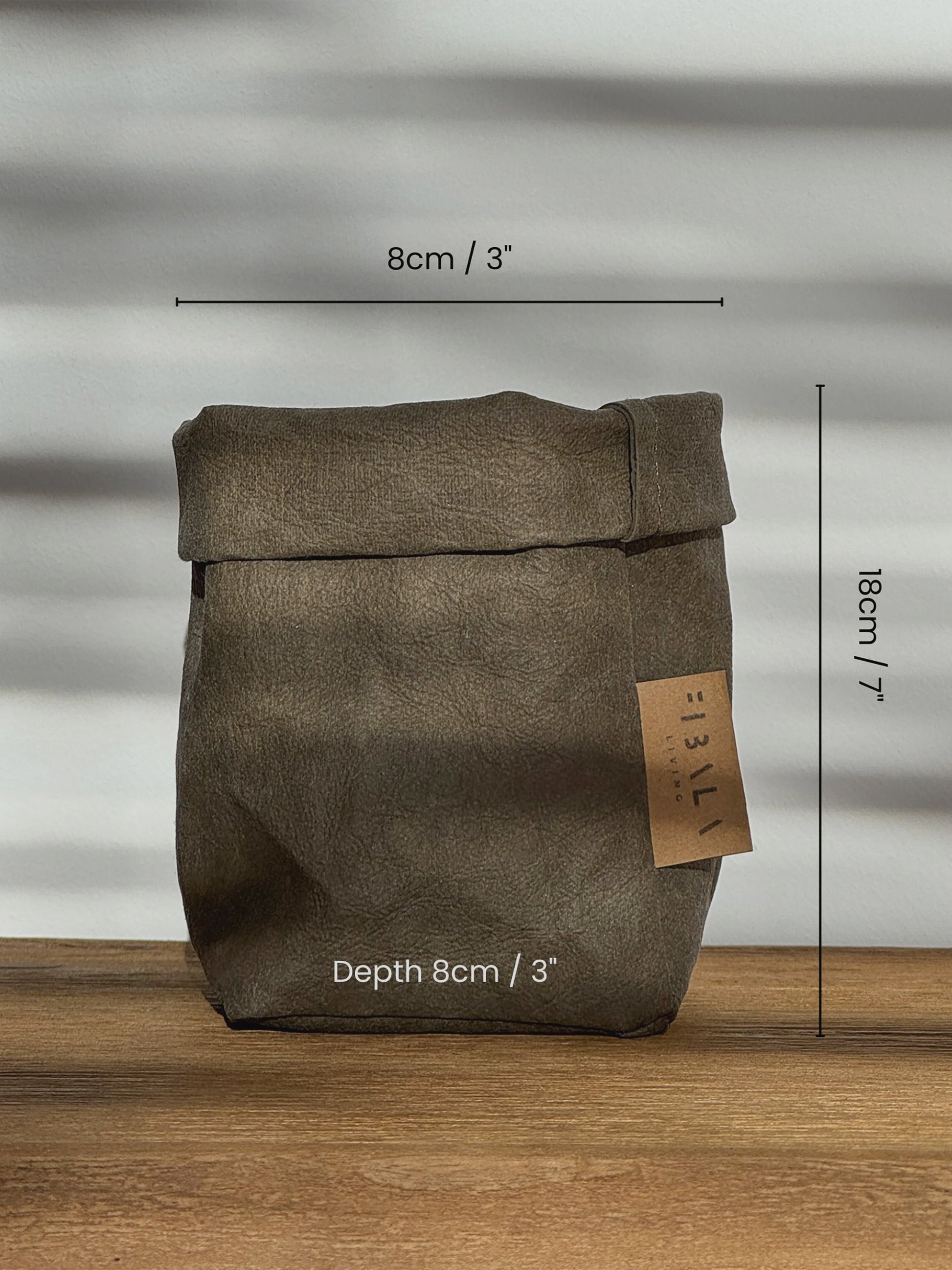 Washable paper bag with dimensions on a wooden surface and gray background
