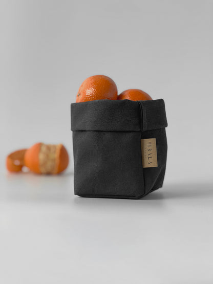Black washable paper bag with mandarines on a light gray background