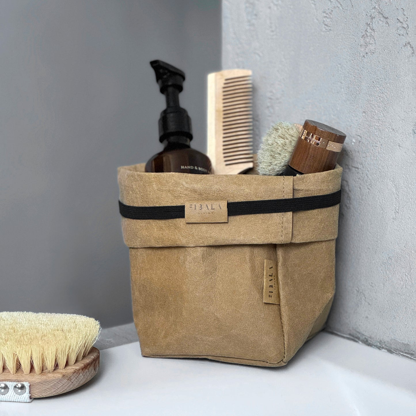 Small Brown Washable Paper Bag with Bathroom Toiletries on Gray Surface, Eco-Friendly and Stylish for Travel and Storage