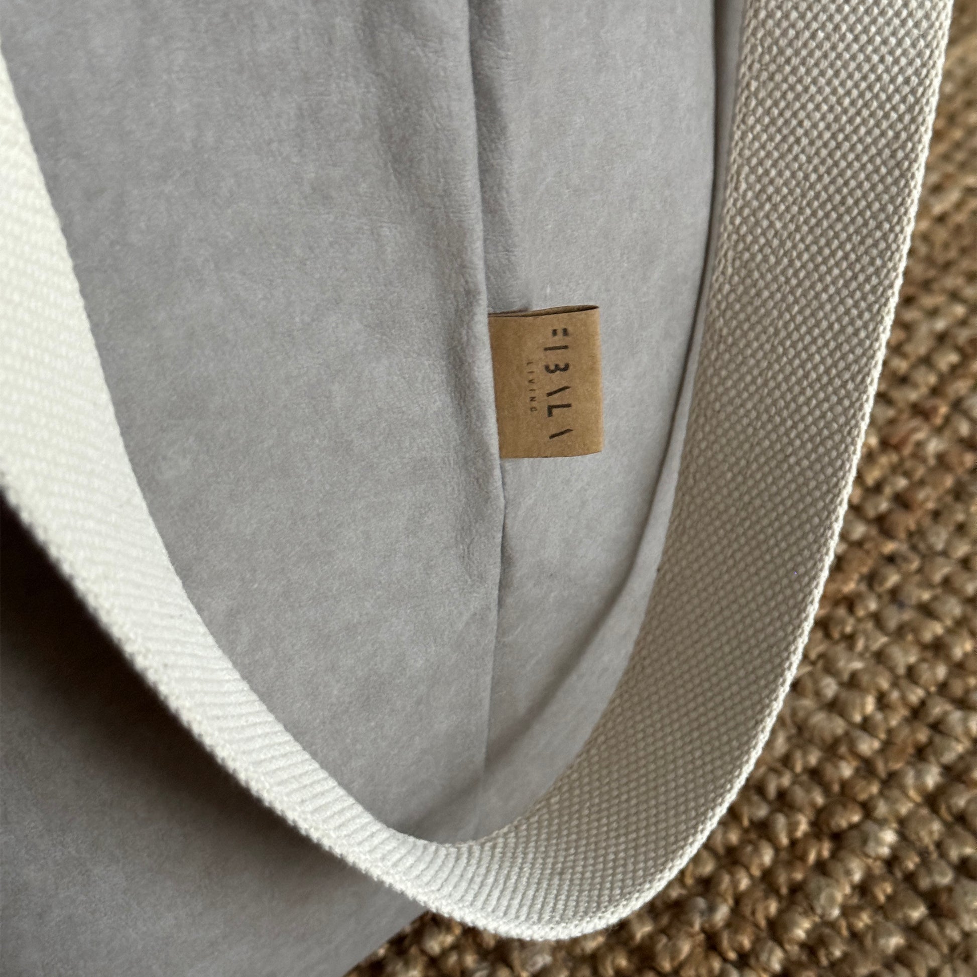 Close-up of gray washable paper laundry basket, long cotton handles, textured eco fabric detail