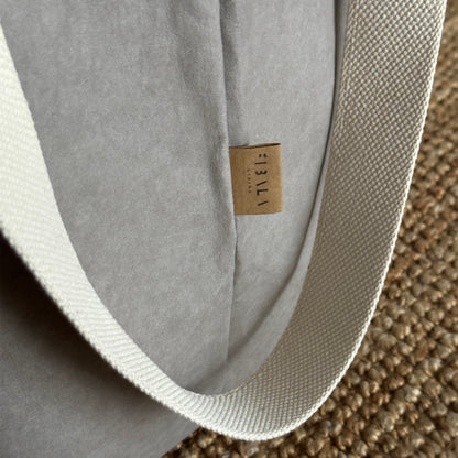 Close-up of gray washable paper laundry basket, long cotton handles, textured eco fabric detail