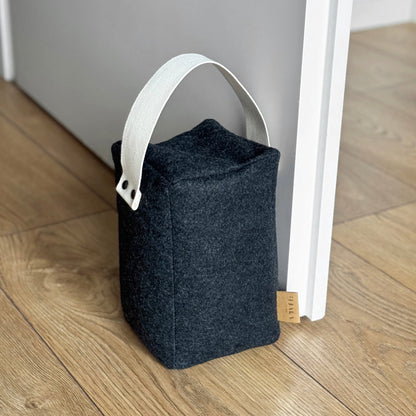 Cozy dark gray wool cube doorstop, natural cotton handle, eco-friendly floor-safe wedge - front view
