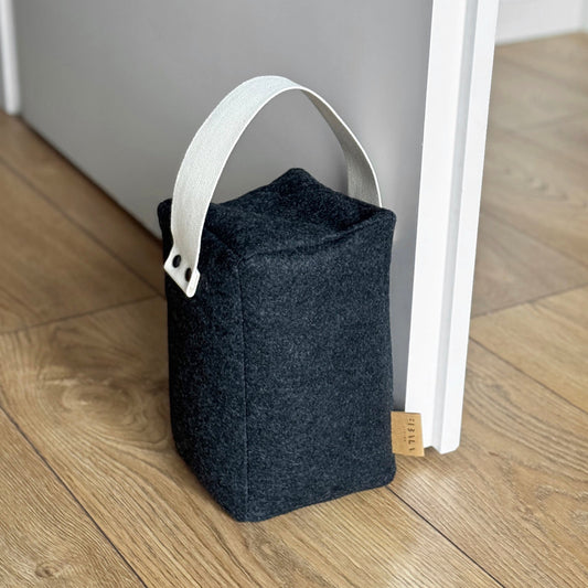 Cozy dark gray wool cube doorstop, natural cotton handle, eco-friendly floor-safe wedge - front view