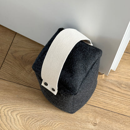 Cozy dark gray wool cube doorstop, natural cotton handle, eco-friendly floor-safe wedge - top view