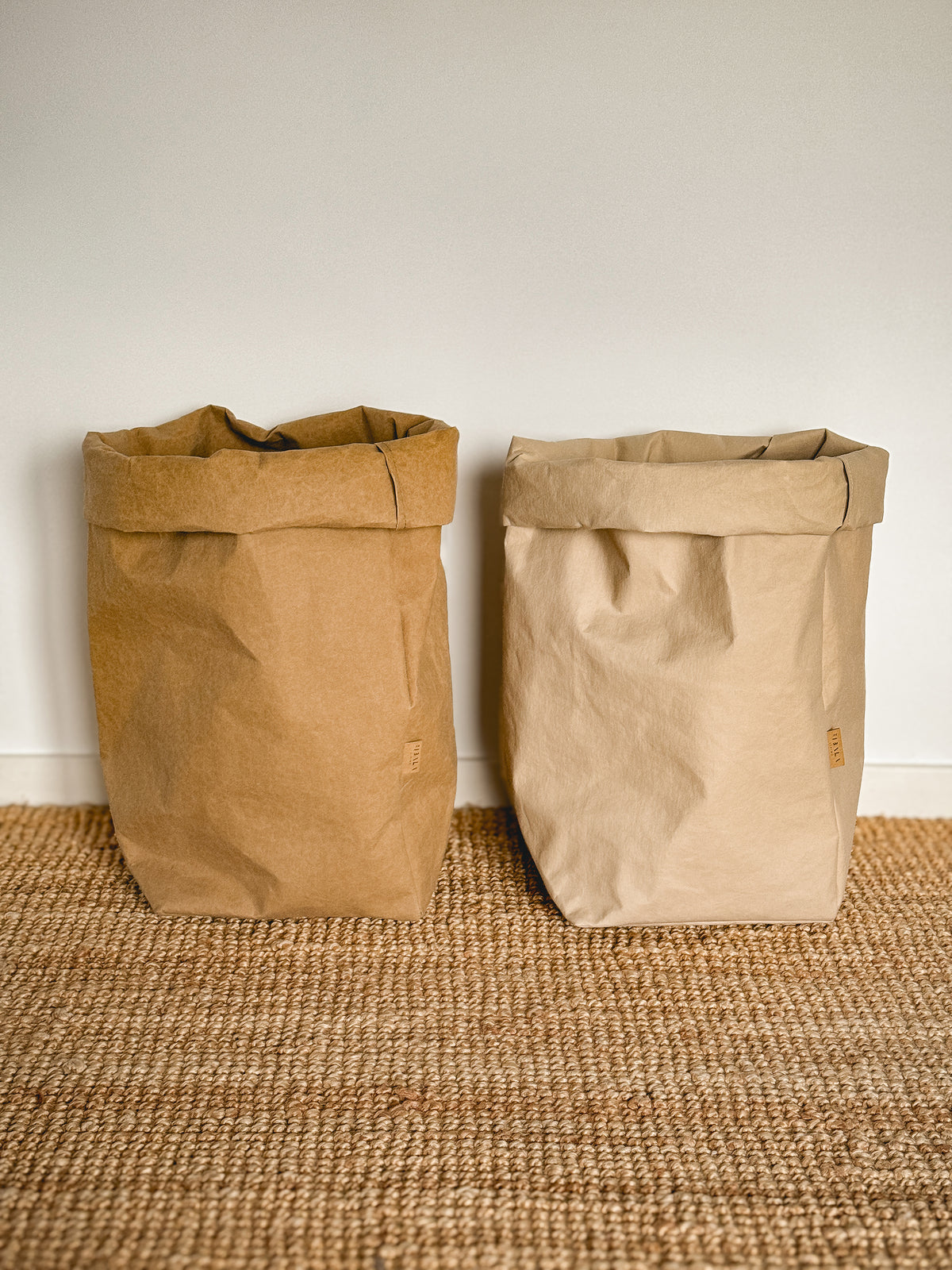 Two XXL washable paper storage bags side by side on a jute rug