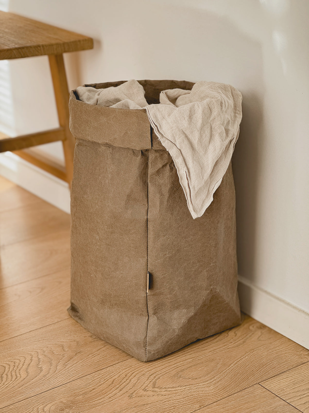 XXL washable paper storage bag with a linen throw in a room corner