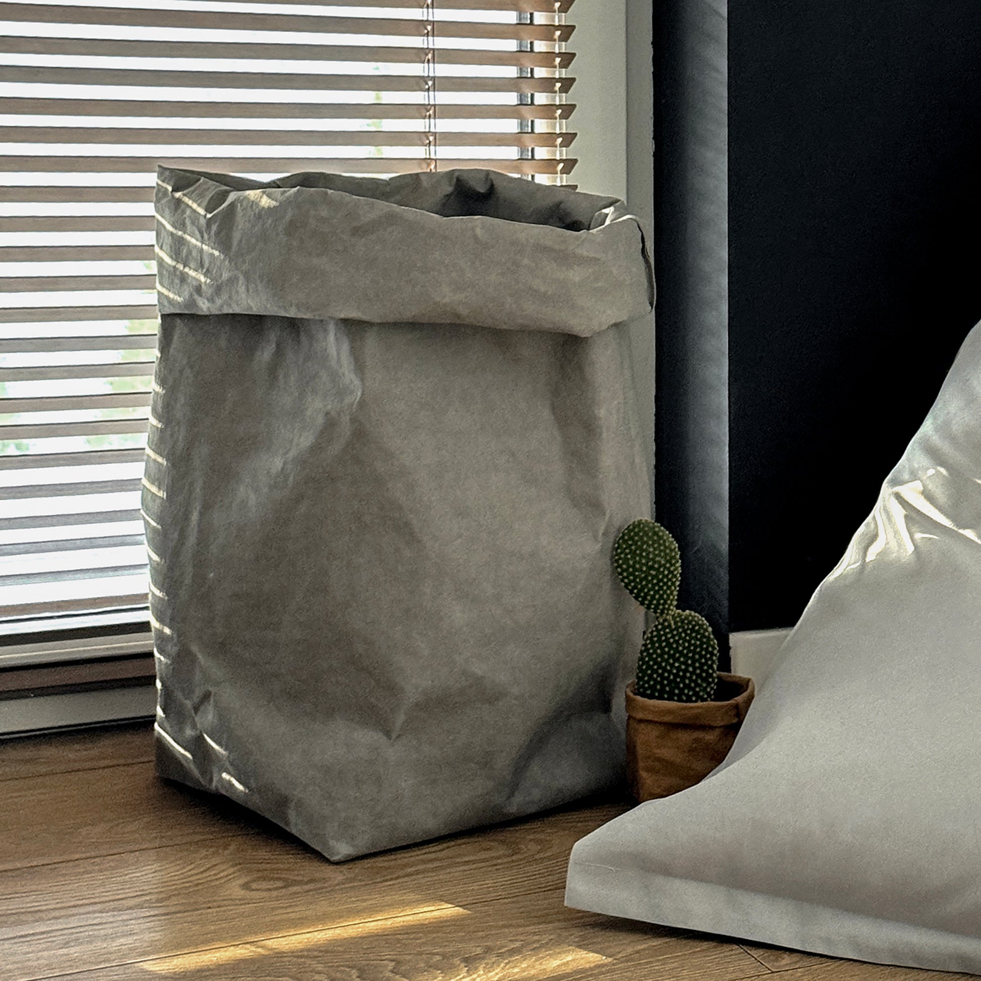 XXL gray washable paper bag, wood floor, window blinds, small plant, eco storage